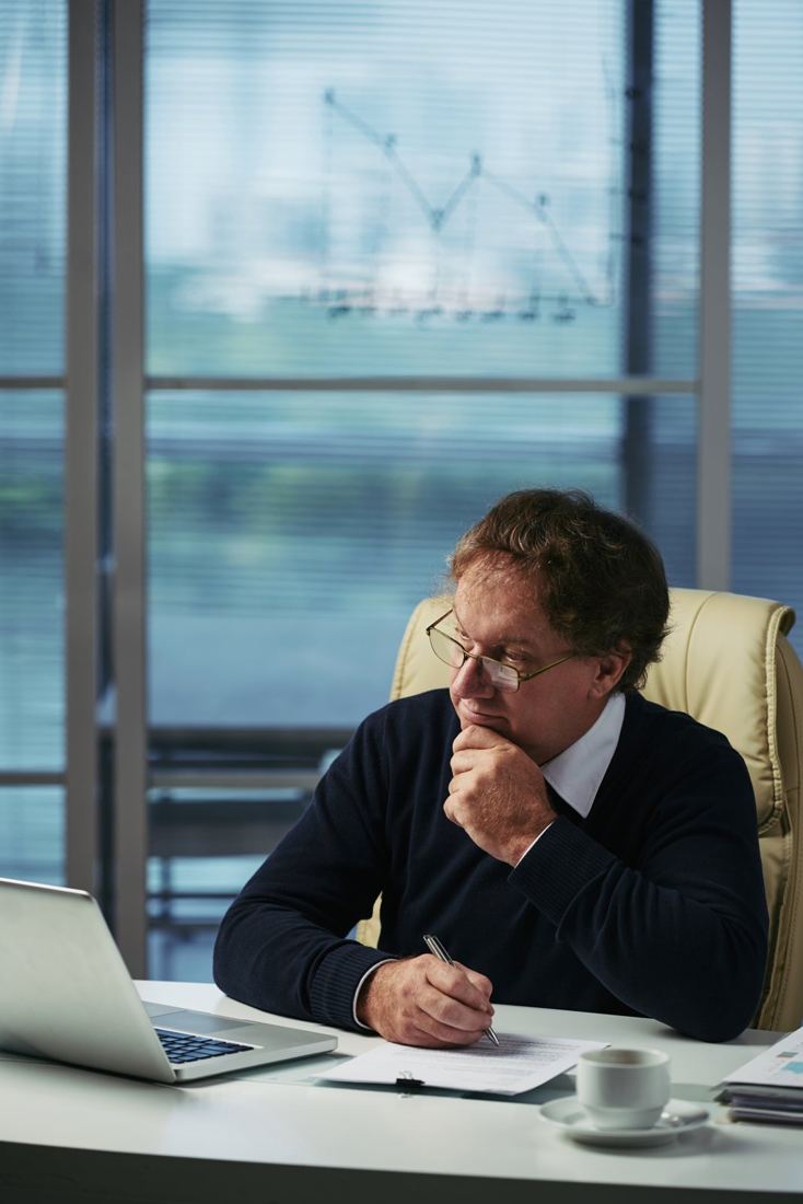 Homem analisando papéis no escritório